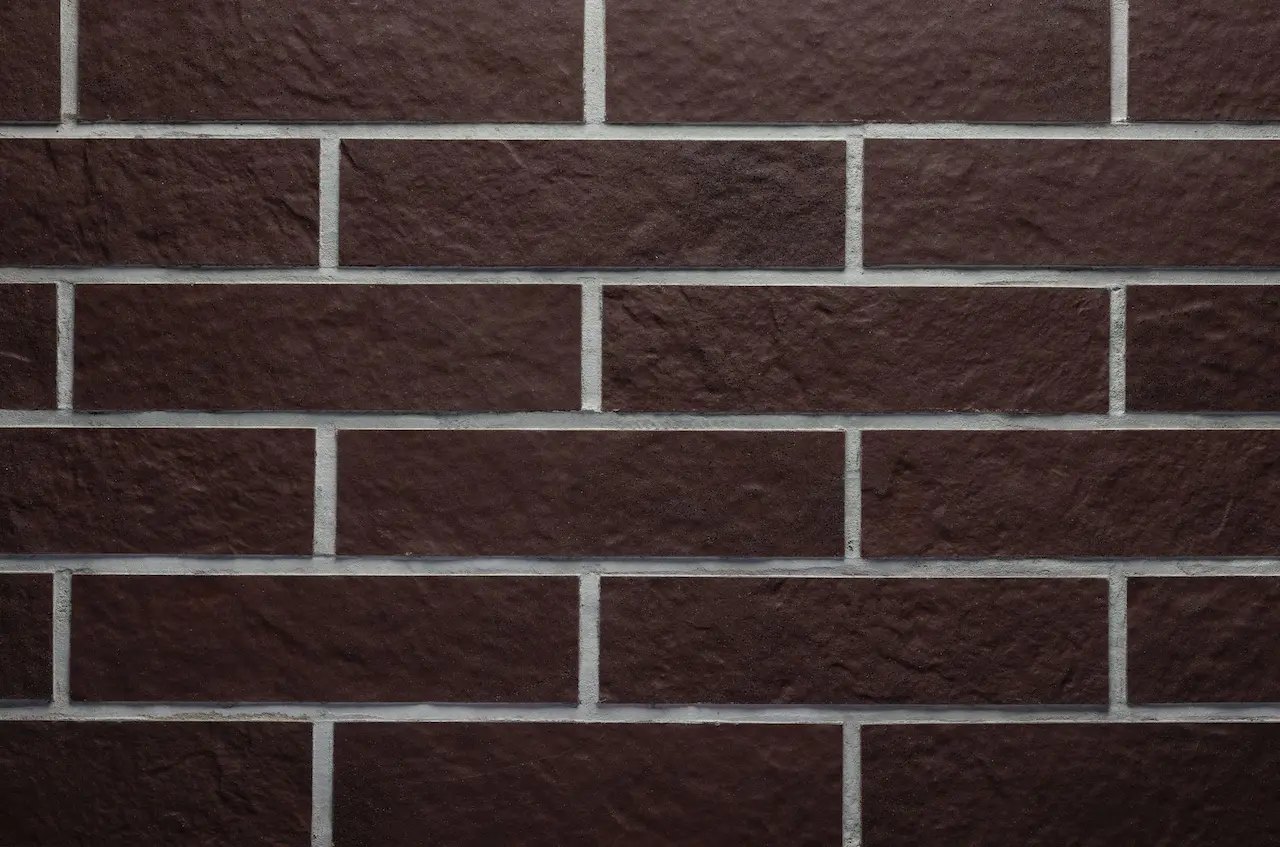 Zidărie maro-ciocolatiu BR07 Chocolate Rock cu rosturi gri deschis și textură rugoasă de piatră