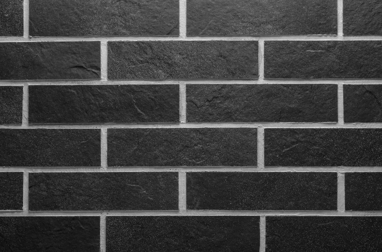 Zidărie negru-antracit BR09 Volcanic Anthracite cu rosturi deschise și suprafață granulată de piatră