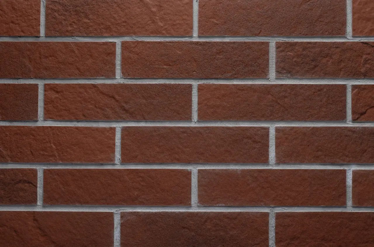 Zidărie teracotă BR10 Loft Red Clay cu rosturi gri deschis și suprafață de piatră în relief